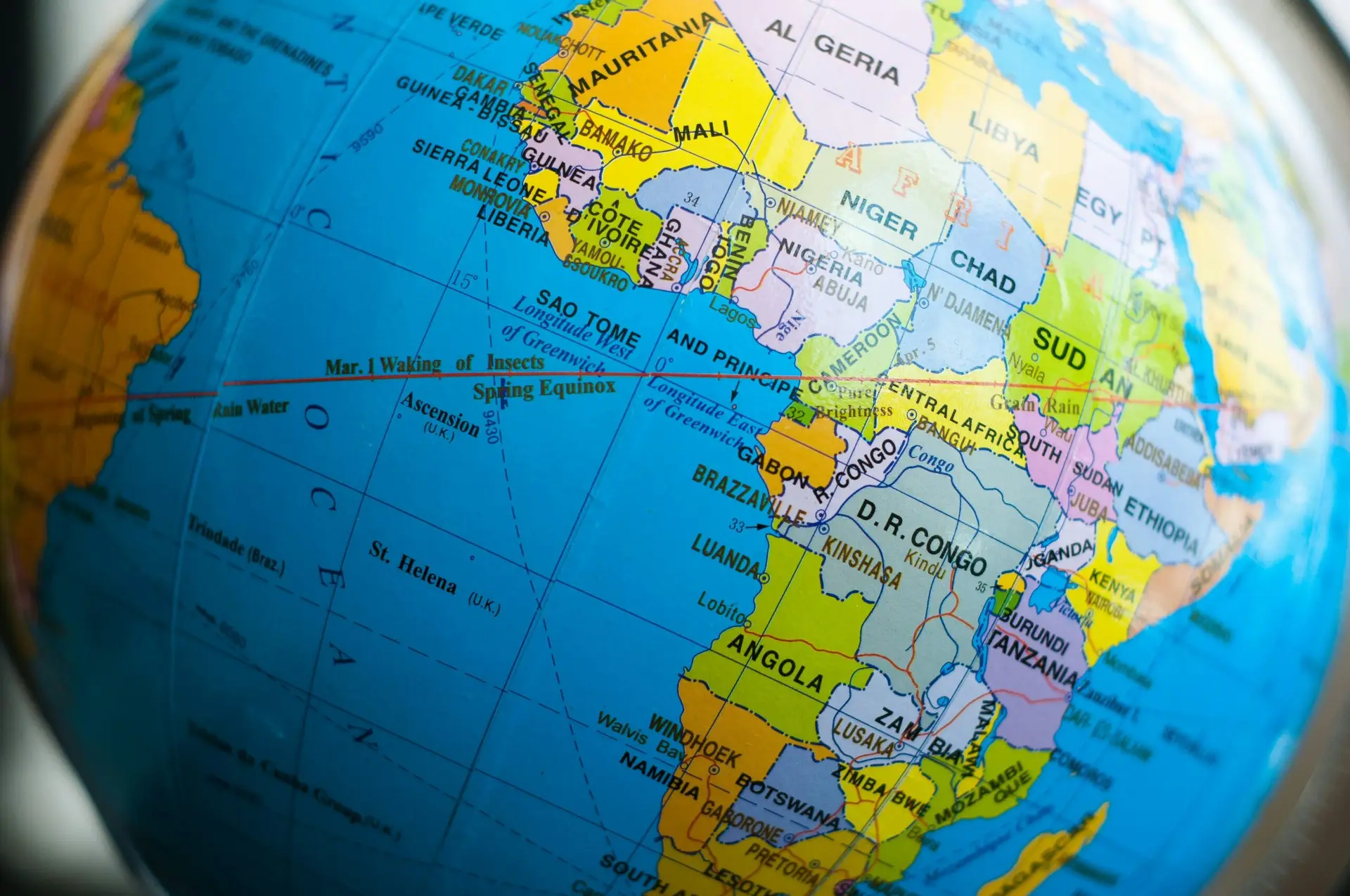 A close-up of a globe showing parts of Europe, the Middle East, and Africa—including regions where circumcision is widely practised—with countries like France, Libya, Nigeria, and Sudan clearly labelled in vibrant colours. Blue oceans surround the continents.