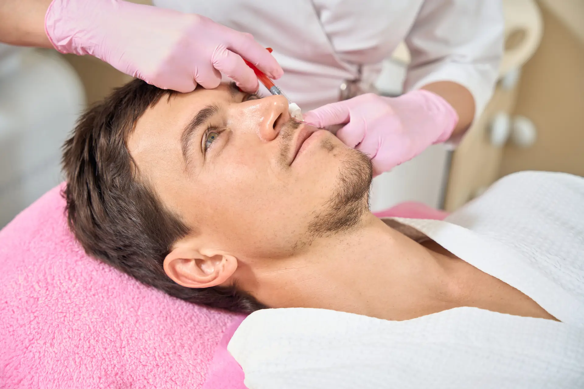 Young man receiving aesthetic skin treatment at a clinic