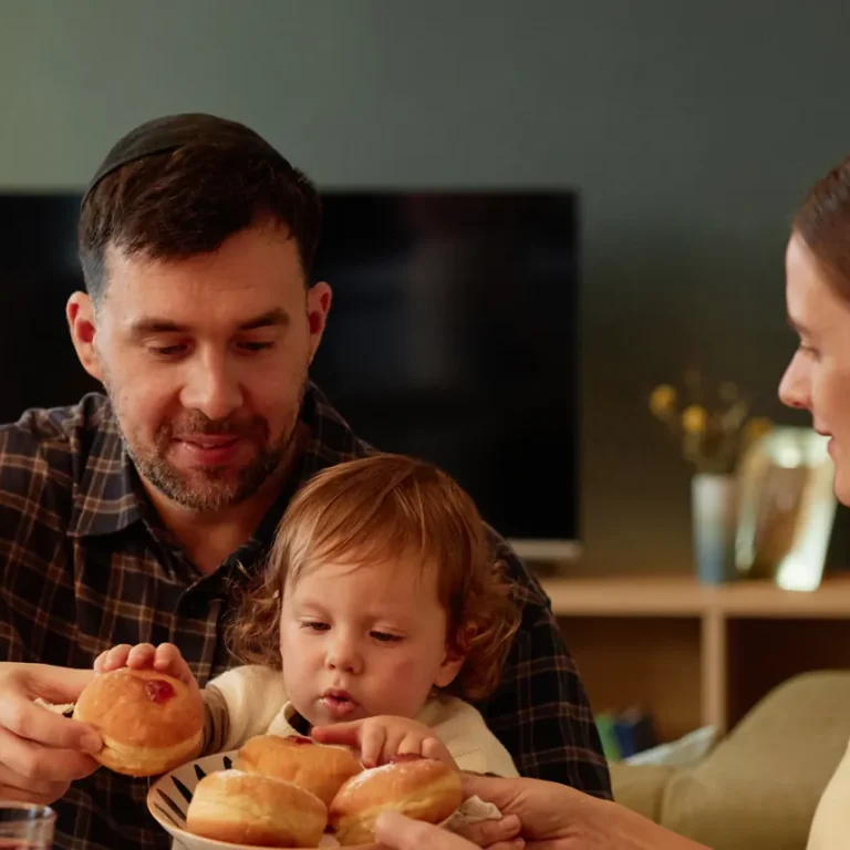 A family of three sits at a table, sharing bread rolls at Gentle Procedures UK, Birmingham