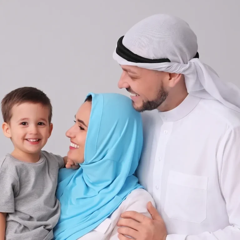 A smiling man in a white kandura and headscarf stands next to a woman in a blue hijab who is holding a young boy