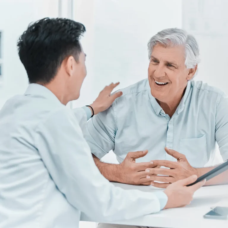 Mature male patient and doctor reviewing medical results on a tablet in clinic