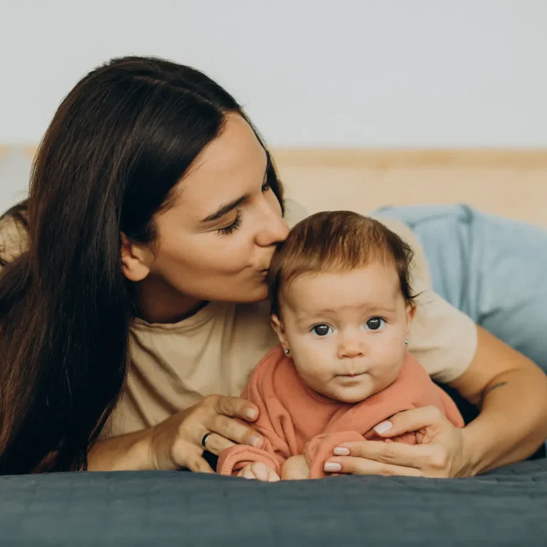 Mother with baby daughter lying on bed