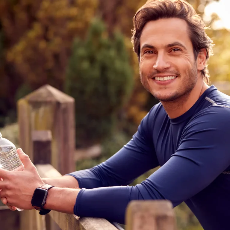 Portrait Of Mature Man Exercising In Countryside With Activity Monitor On Smart Watch